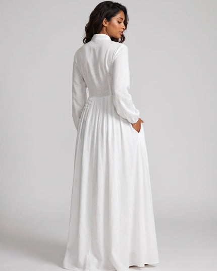 Woman wearing a long white dress against a plain background