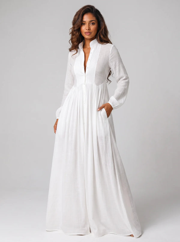 Woman wearing a long white dress against a plain background