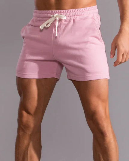 Pink pull-on athletic shorts with cream contrast drawstring