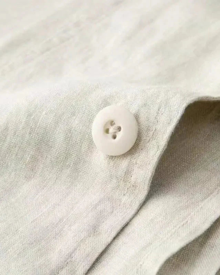 Close-up of beige linen-blend fabric texture showing button and weave detail