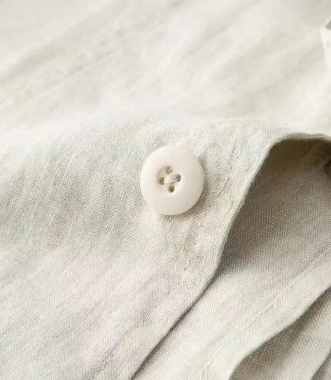 Close-up of beige linen-blend fabric texture showing button and weave detail