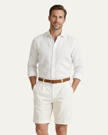 White pleated chino shorts on model with white button-up shirt