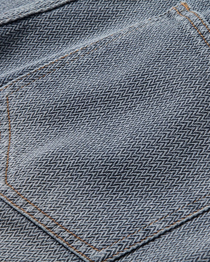 Close-up of front pocket and waistband hardware on denim shorts