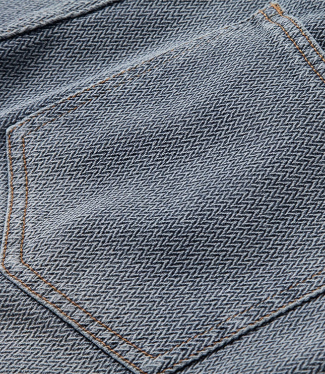 Close-up of front pocket and waistband hardware on denim shorts