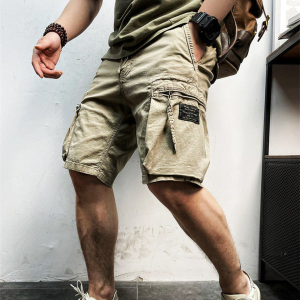Khaki cargo shorts with drawstring waistband and multiple side pockets worn on model