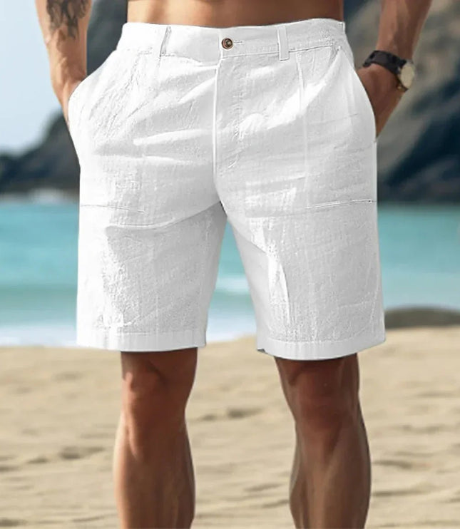White men's linen flat front knee length shorts with button waist on beach