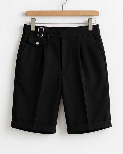 Black pleated shorts with buckle adjusters and front pockets displayed on hanger