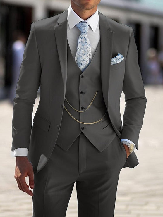 Charcoal gray formal three piece suit with single breasted blazer, vest and chain detail