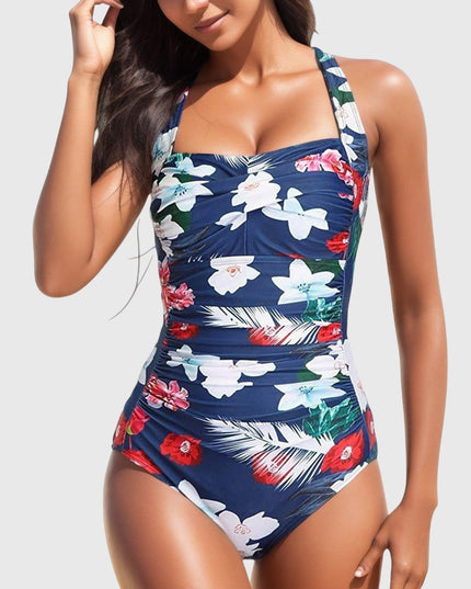 Navy one-piece swimsuit with white and red tropical flowers and ruched details