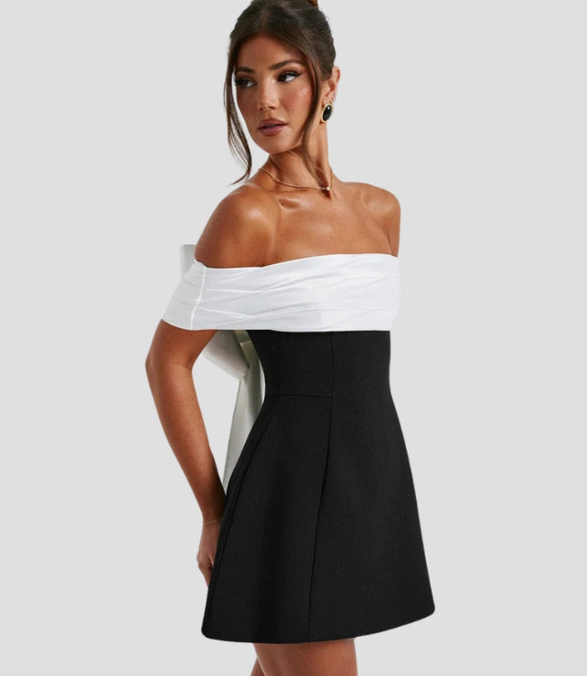 Women white and black cocktail mini dress with off-shoulder top and black flared skirt, side view