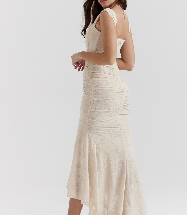 Back view of a cream floral corset midi dress showing the ruched detailing and flowing high-low skirt.