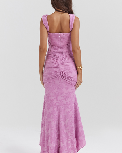 Back view of a women's pink floral corset asymmetric midi dress with ruched detailing and a subtle floral pattern, for graduation.