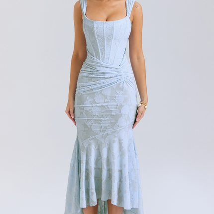 Light blue women's graduation dress with floral jacquard pattern, corset bodice, and asymmetric midi hemline, paired with white heels.