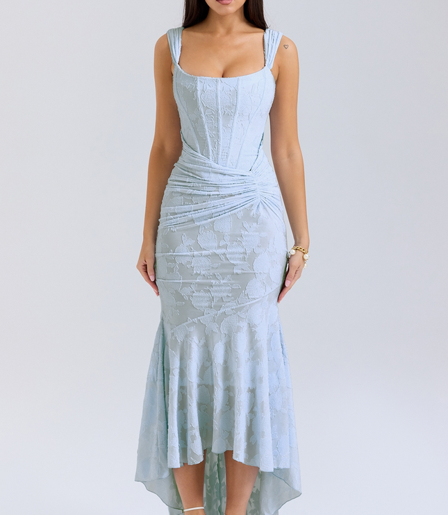 Light blue women's graduation dress with floral jacquard pattern, corset bodice, and asymmetric midi hemline, paired with white heels.