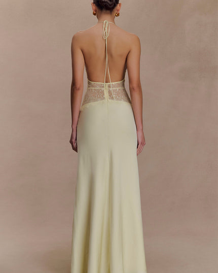Back view of a light yellow halter neck maxi dress with delicate lace details on the back bodice.