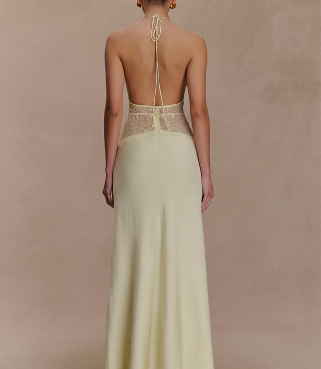 Back view of a light yellow halter neck maxi dress with delicate lace details on the back bodice.