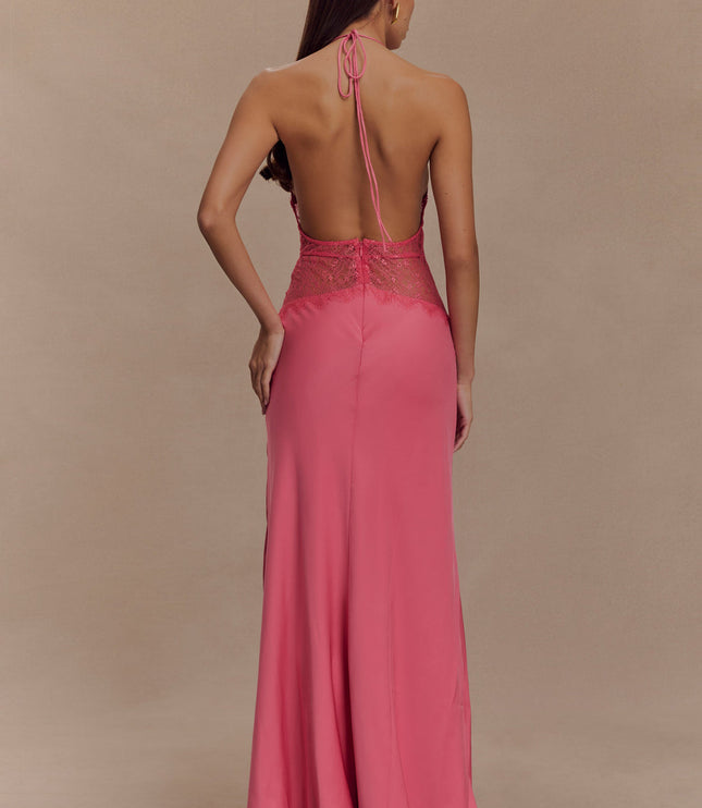 Back view of a women's pink halter neck maxi dress with an open back and intricate lace on the bodice.