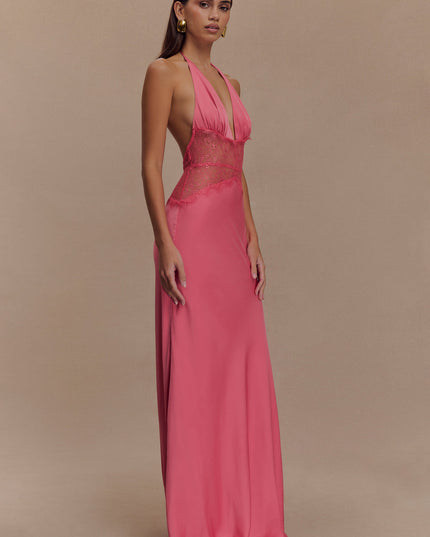 Side profile of a women's pink halter neck maxi dress, showcasing the deep V-neck and lace paneling.