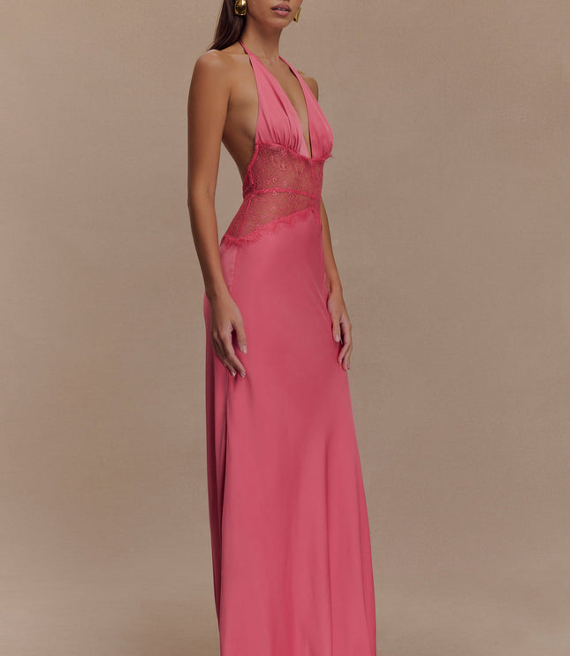 Side profile of a women's pink halter neck maxi dress, showcasing the deep V-neck and lace paneling.
