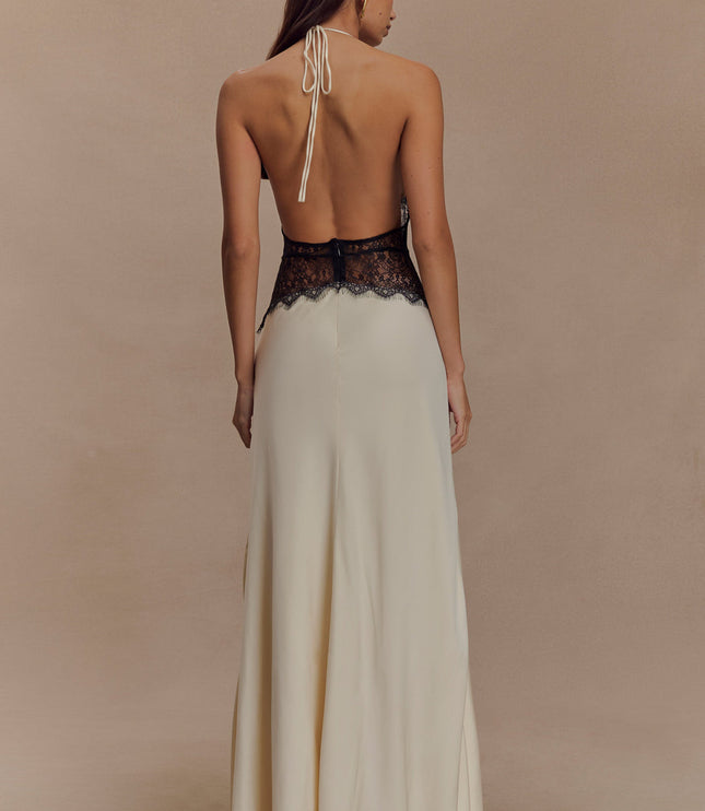 Back view of cream halter neck maxi dress with black lace detail, showing open back and tie closure.