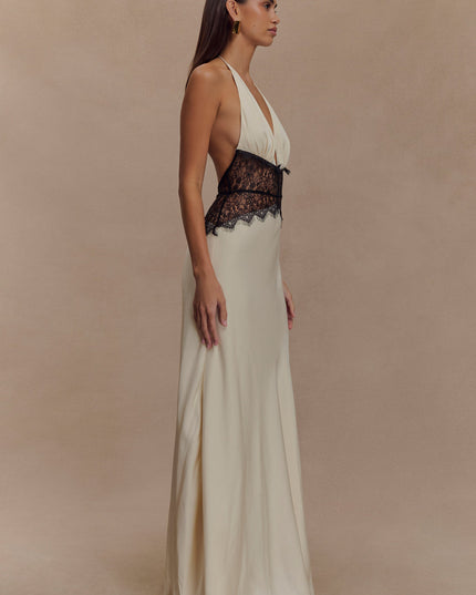 Side profile of cream halter neck maxi dress featuring a deep V-neck and black lace mid-section.