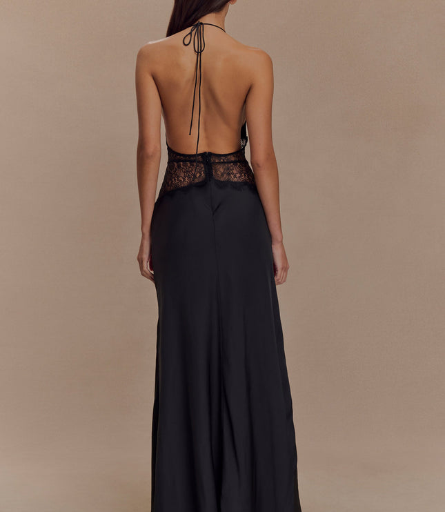 Rear view of a black halter neck maxi dress, showcasing the open back and delicate lace trim.