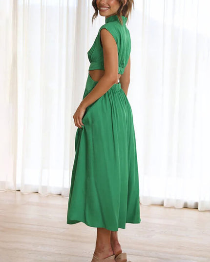 Side view of a green high neck cut out pleated midi dress, showing flowy skirt detail.