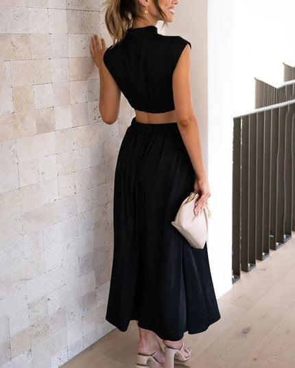 Back view of a black high neck pleated midi dress, showcasing the cut-out waist detail.