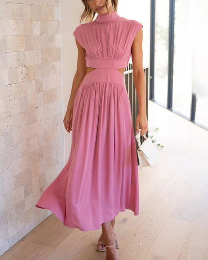 Pink high neck cut out pleated midi dress with cap sleeves, flowing skirt, and white clutch.