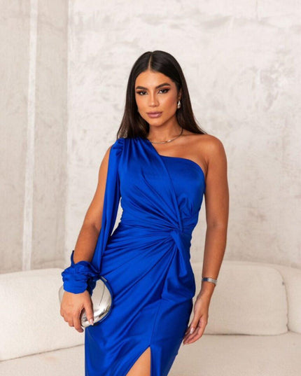 Royal blue one shoulder maxi dress with ruched waist and high slit. The elegant dress features a long flowing sleeve.