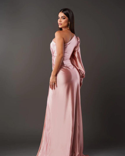 Back view of a light pink one shoulder maxi dress, the smooth satin fabric and long sleeve of the women's dress.