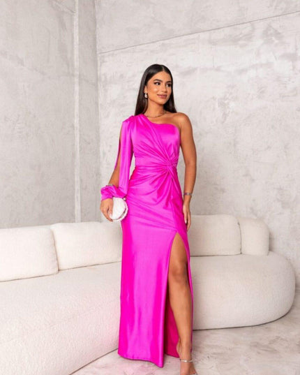 Bright fuchsia pink one shoulder ruched maxi dress with a high slit and long sleeve detail, a vibrant women's dress.