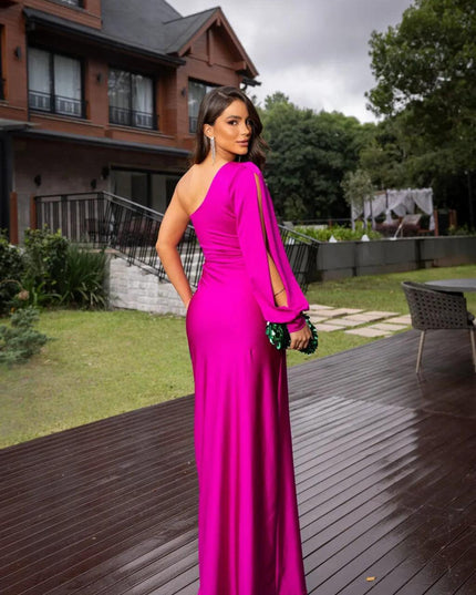 Back view of a fuchsia one-shoulder ruched maxi dress with a long sleeve, showing the smooth fabric.