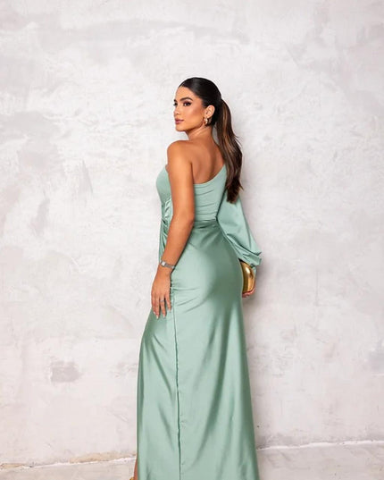 Back view of a women's light green one-shoulder maxi dress, highlighting the elegant drape of the fabric