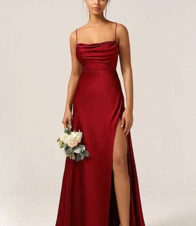 Burgundy satin cowl neck maxi dress with spaghetti straps, high slit, and a small flower bouquet.
