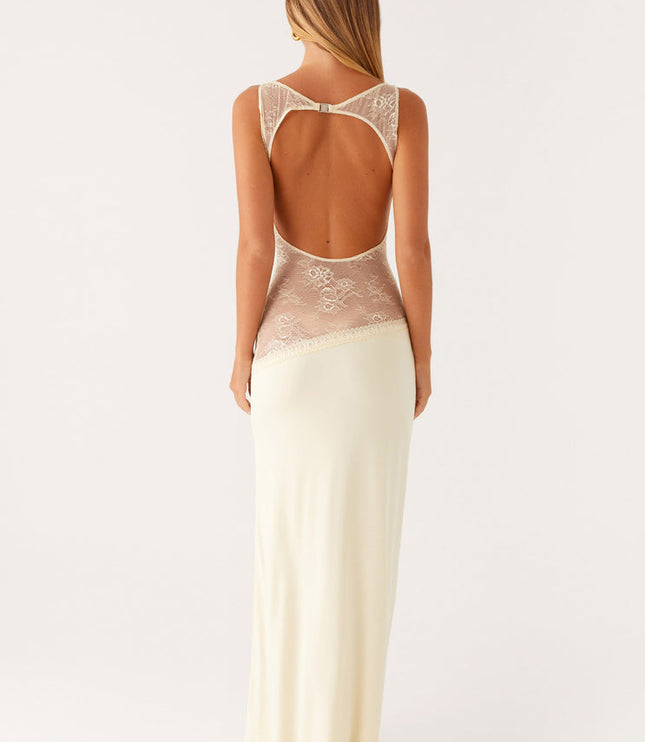 Back view of an ivory sleeveless maxi dress with a low open back and intricate lace detailing on the upper back and waist.