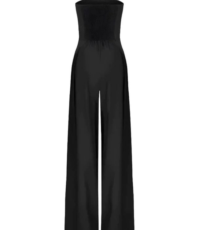 Black strapless wide leg jumpsuit with pocket detail styled on a model against draped backdrop