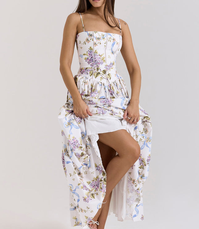 Full length view of a white women's floral corset midi dress with purple and blue patterns, showing a leg and white high heels.