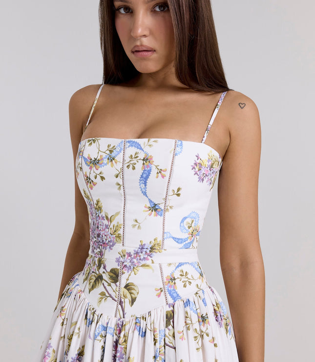 Close-up of the bodice of a women's white floral corset midi dress with delicate purple and blue flower patterns.