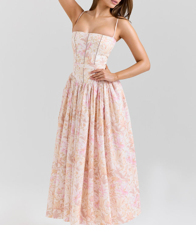 Full-length view of the women's summer floral corset midi dress in light pink and peach, with hands on hips.