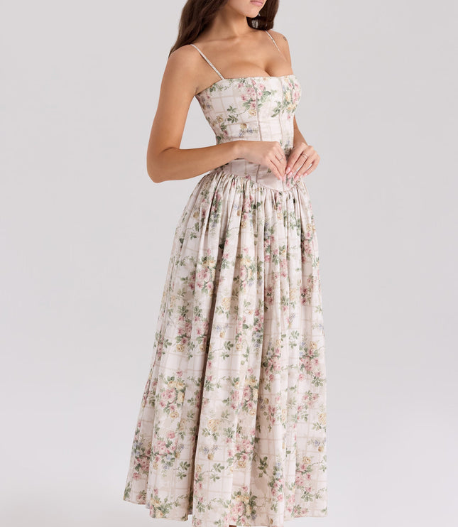 Women's white and pink floral corset midi dress, posed with hands clasped, highlighting the dress's silhouette.