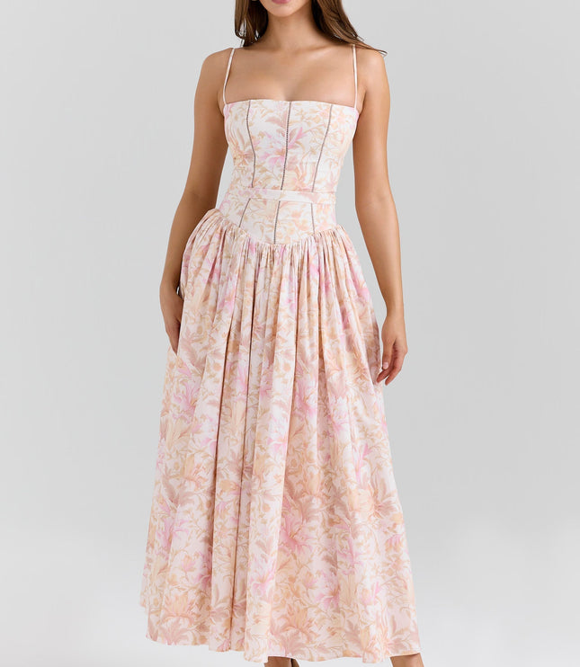 Women's summer floral corset midi dress in light pink and peach hues with spaghetti straps and a full skirt.