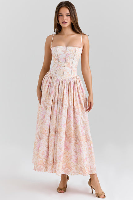 Women's summer floral corset midi dress in light pink and peach hues with spaghetti straps and a full skirt.