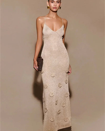 Front view of a shimmering champagne maxi dress featuring a V-neck, thin straps, and subtle floral appliques on the skirt.