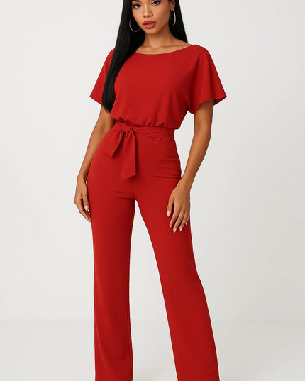 Red wide leg jumpsuit with short sleeves, tie waist belt, and flowing leg shape