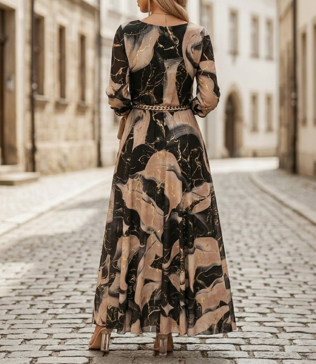 Back view of abstract print maxi dress with long sleeves, flowing skirt, and chain belt detail