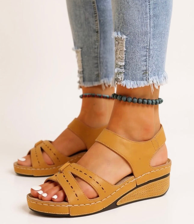 Mustard yellow platform sandals with perforated buckle straps and textured sole