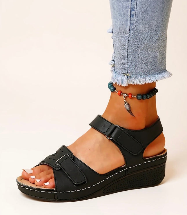 Black wedge platform sandals with wide adjustable straps and white topstitching
