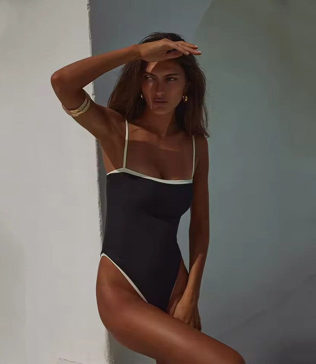 Black bandeau one piece swimsuit with white trim and thin straps