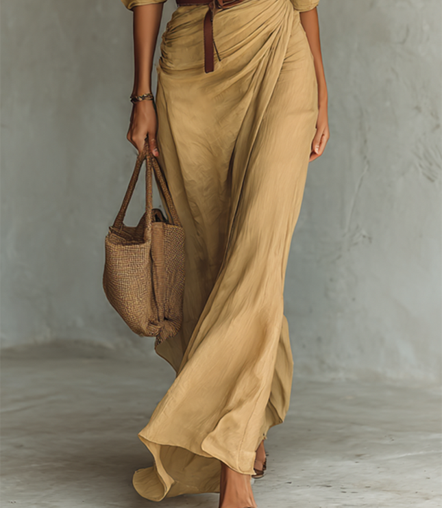Beige maxi dress detail showing ruched skirt and brown leather belt
